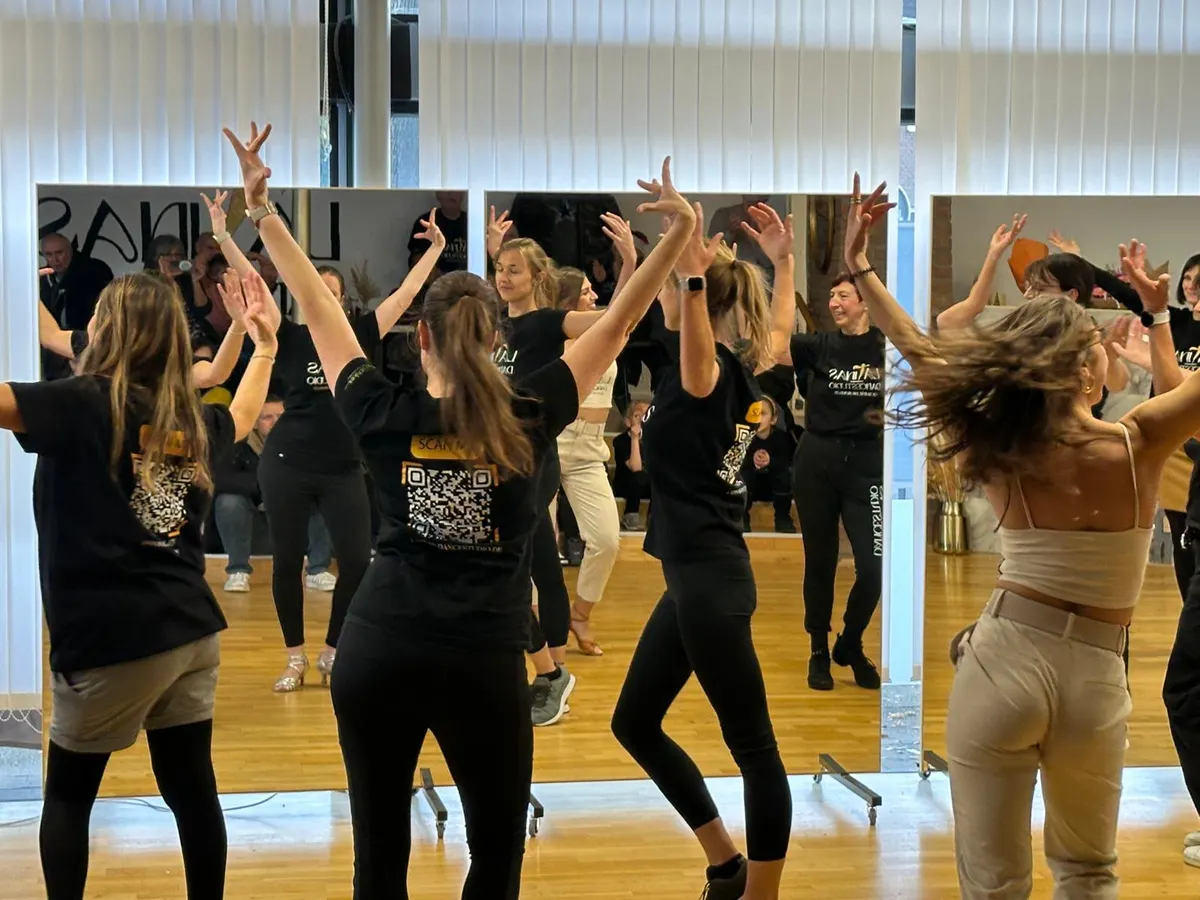 Erwachsene tanzen mit erhobenen Armen im Spiegelsaal von LaTinas Dancestudio