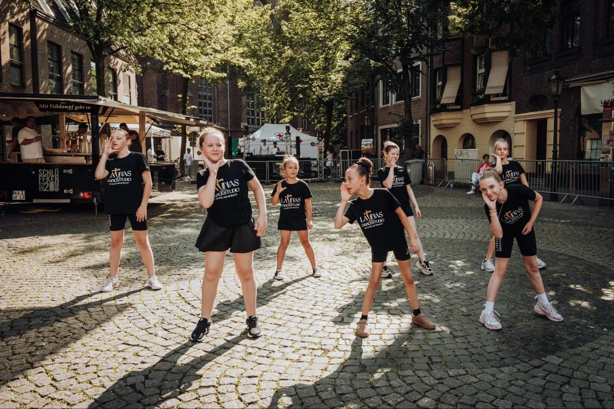 Commercial-Dance-Gruppe von LaTinas Dancestudio posiert bei einem Auftritt unter freiem Himmel
