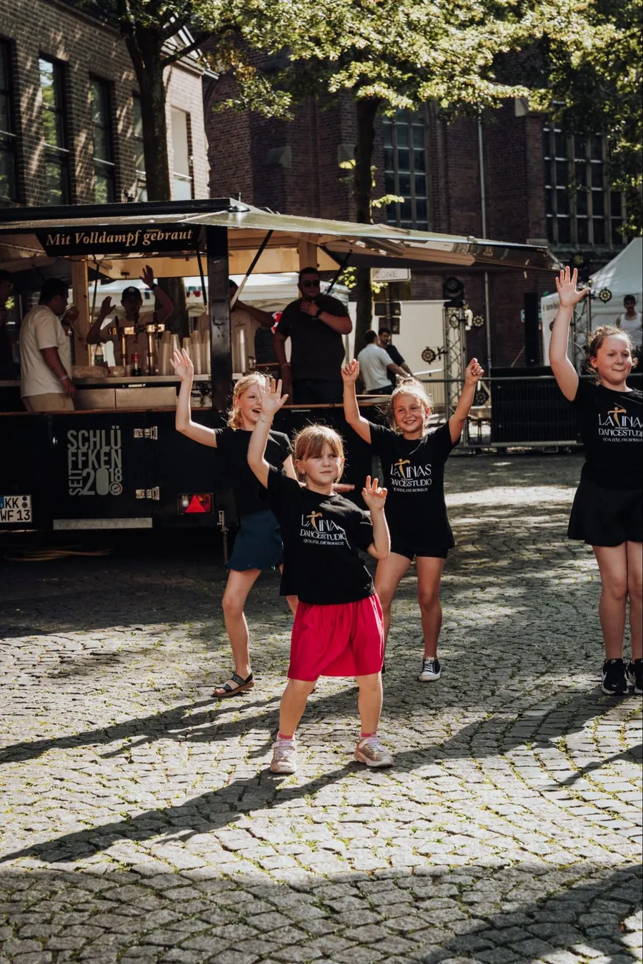 Video Clip Kids von LaTinas Dancestudio tanzen in schwarzen Studio-Shirts bei einem Auftritt auf dem Marktplatz